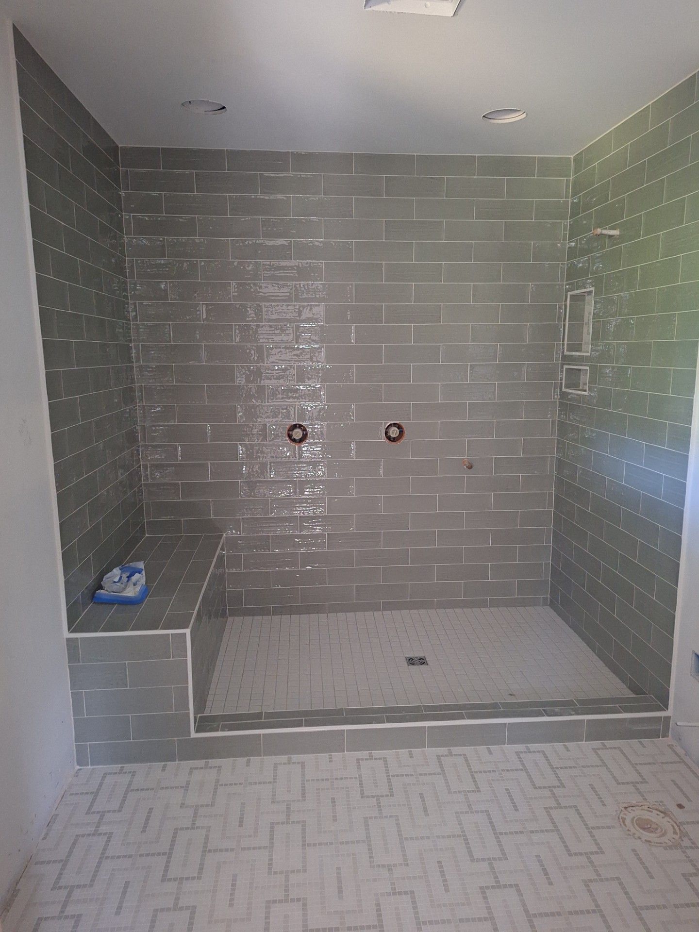 Tools and wood planks on flooring during installation; includes a hammer, saw, and measuring tape.