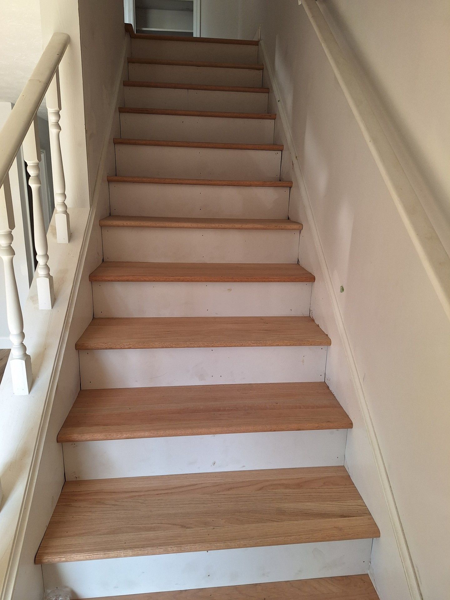 Person laying black and white patterned tiles on a floor, using a trowel and bucket of mortar.