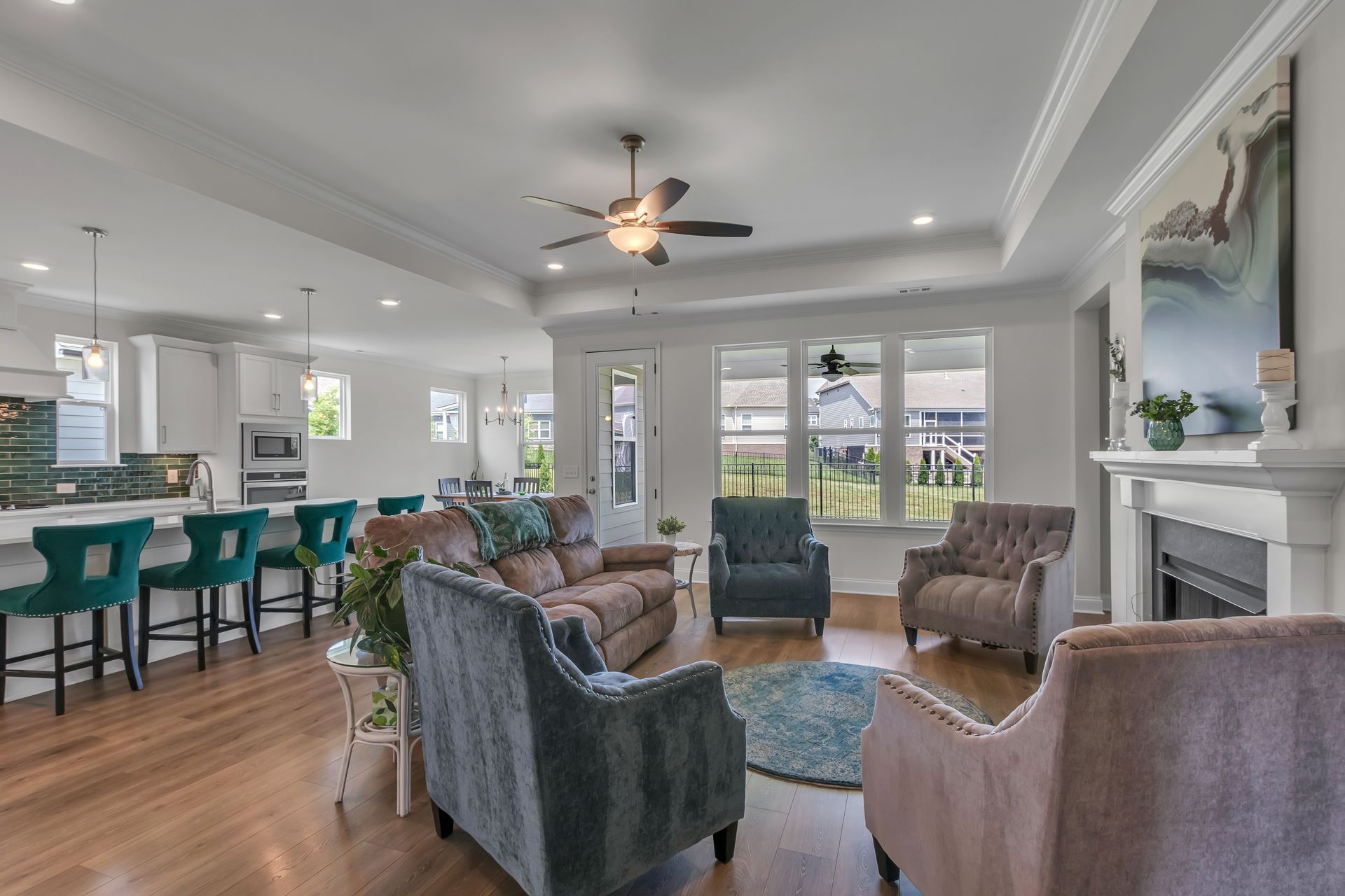 Open-concept living space with a kitchen, living room with seating, fireplace, and large windows.