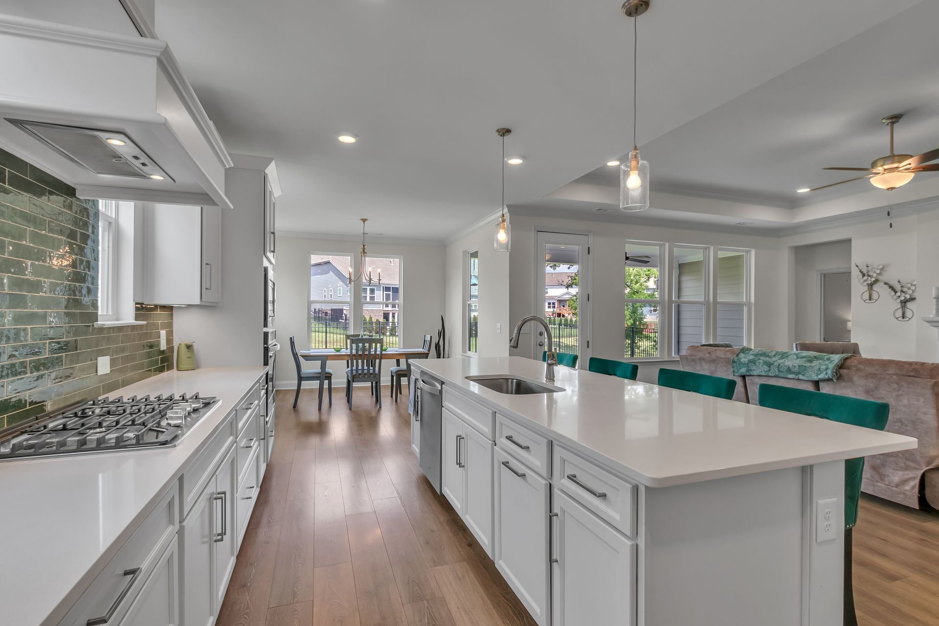 Bright modern kitchen with white cabinets, island, and open dining area.