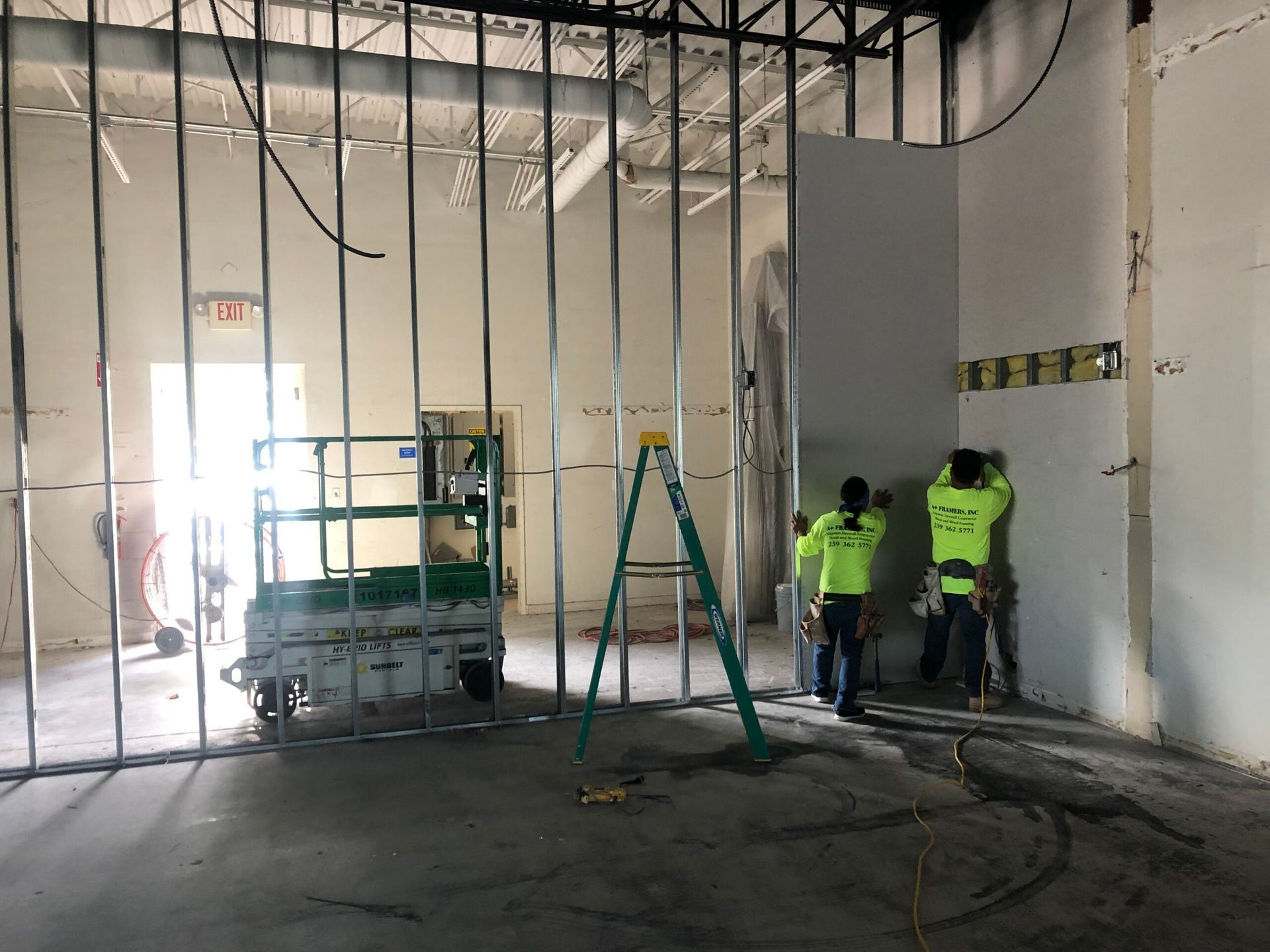 A group of construction workers are working on a wall in a building.