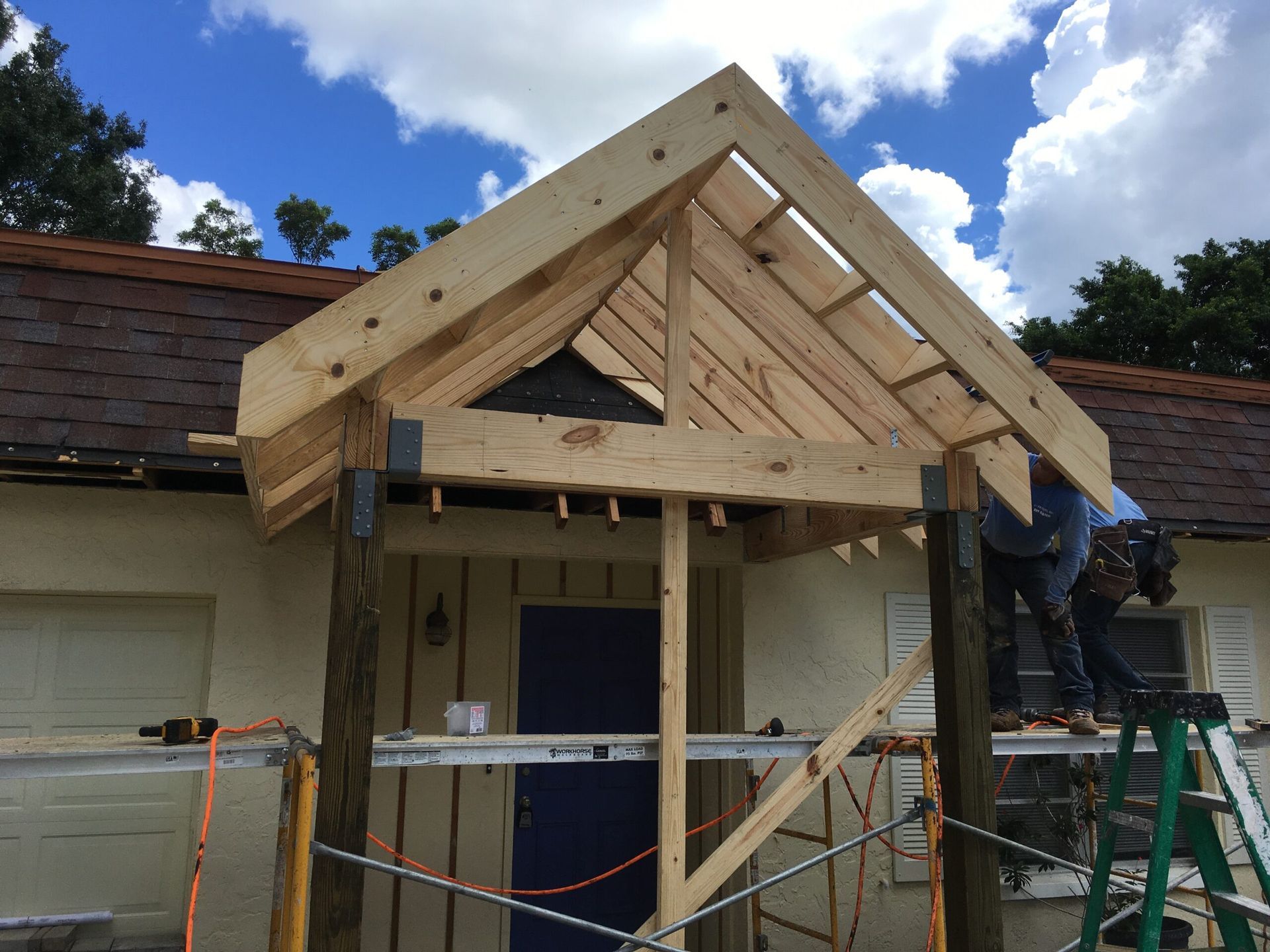 A wooden structure is being built on top of a house.