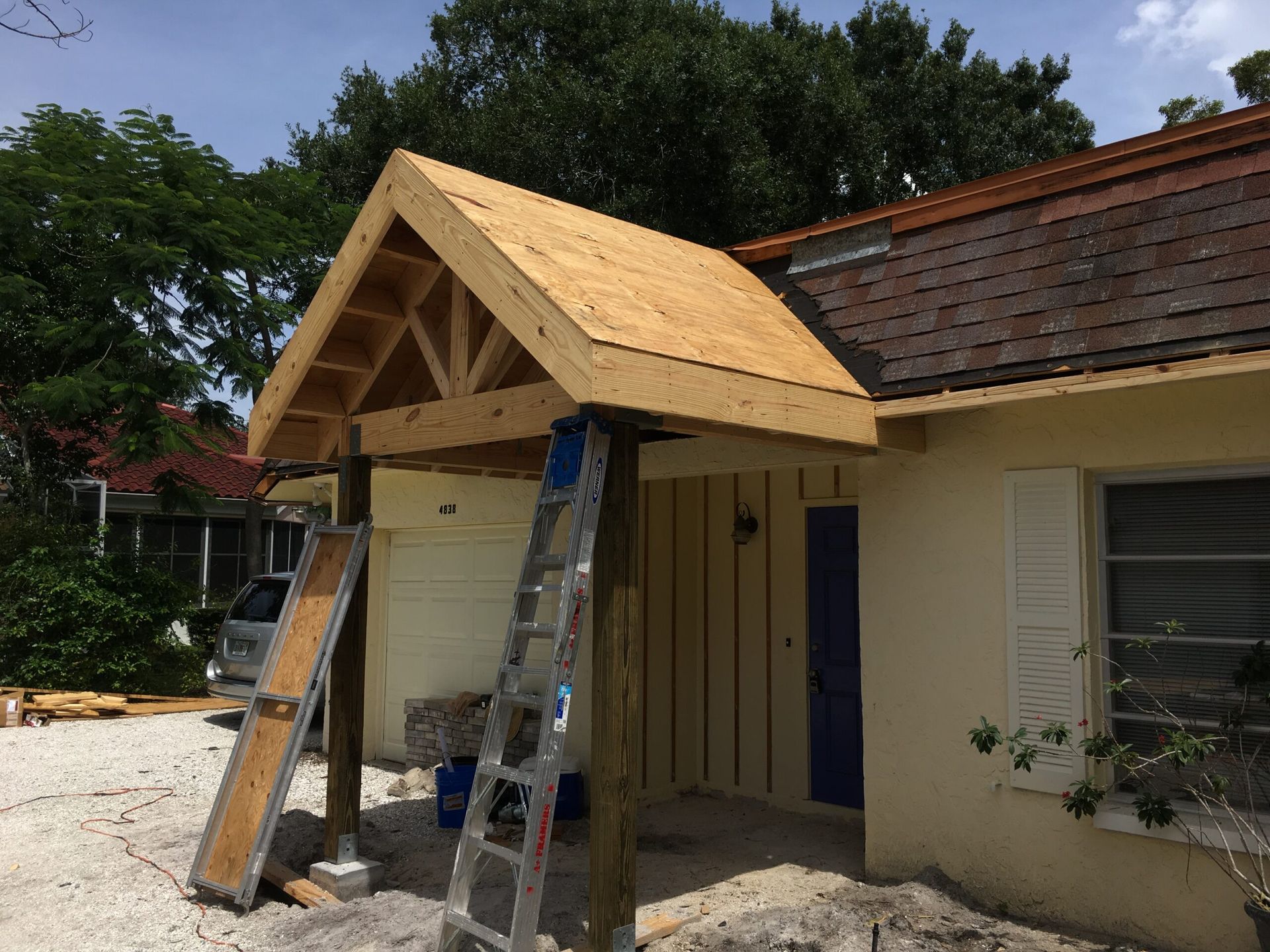 A ladder is sitting in front of a house under construction