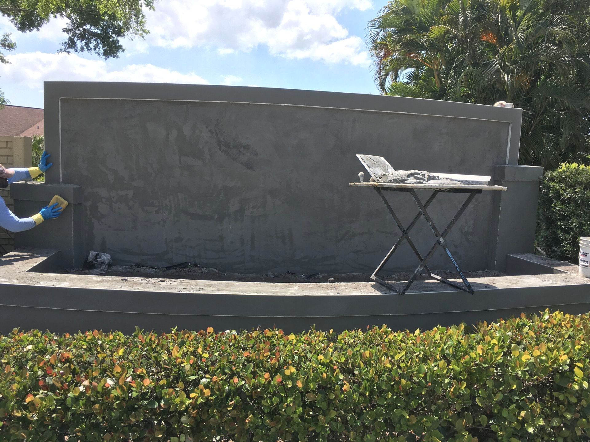 A man is painting a stone wall with a brush