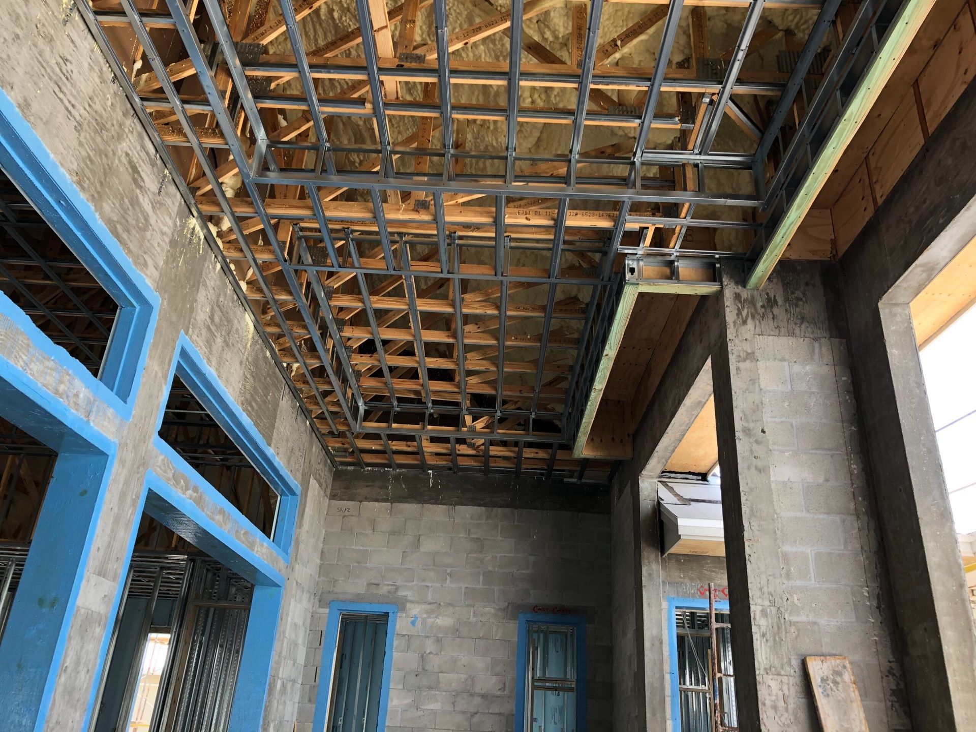 A building under construction with a ceiling made of wood and metal.