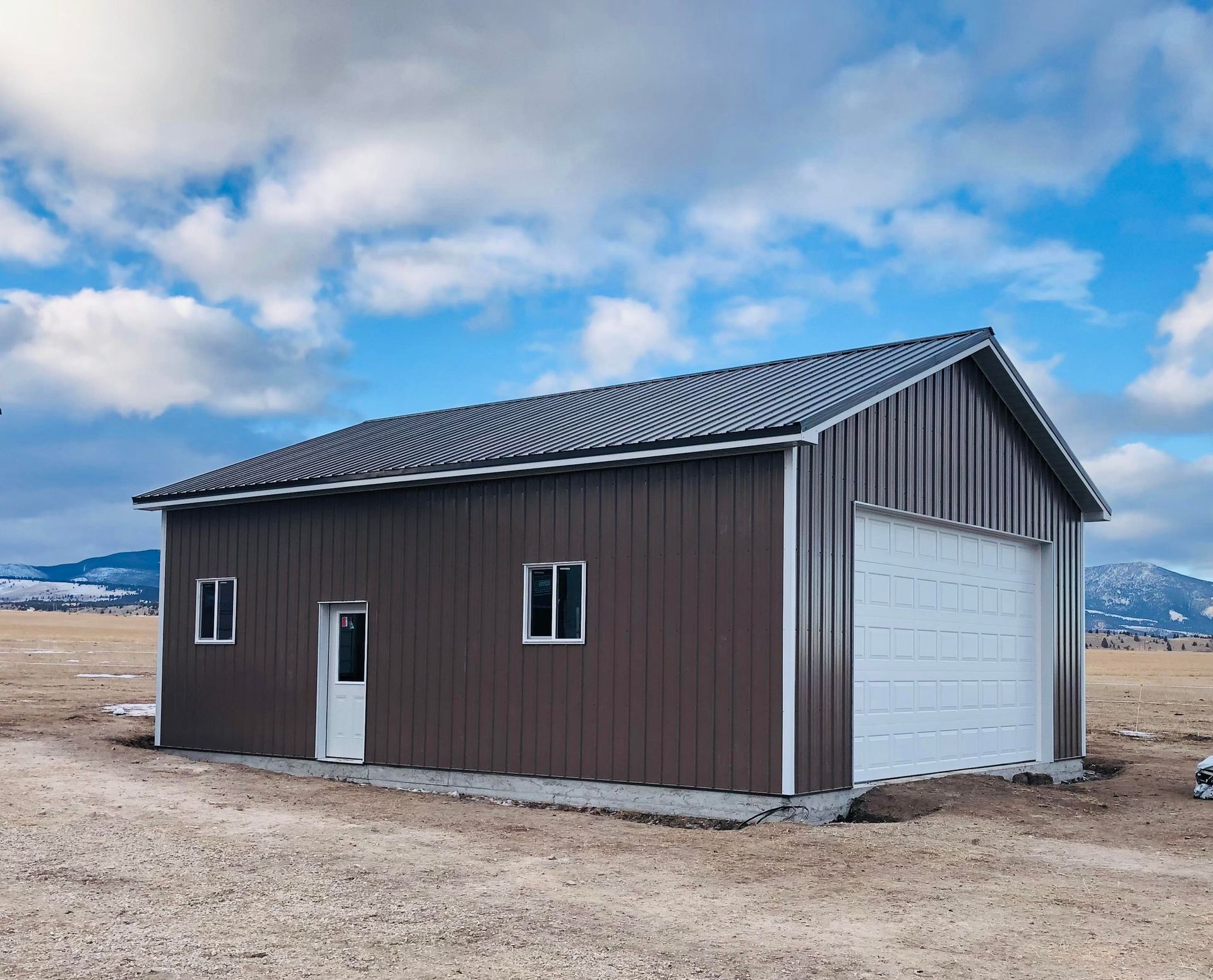 A man is laying a roll of grass in a garden.