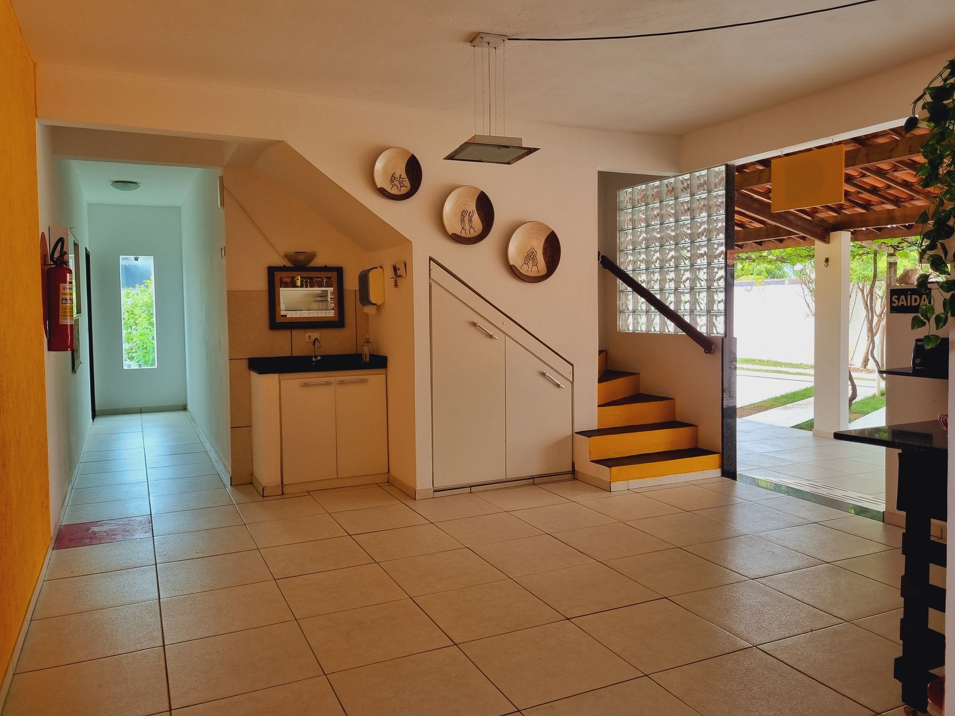 Um corredor com escadas que levam ao segundo andar Pousada Cantinho da Melão
