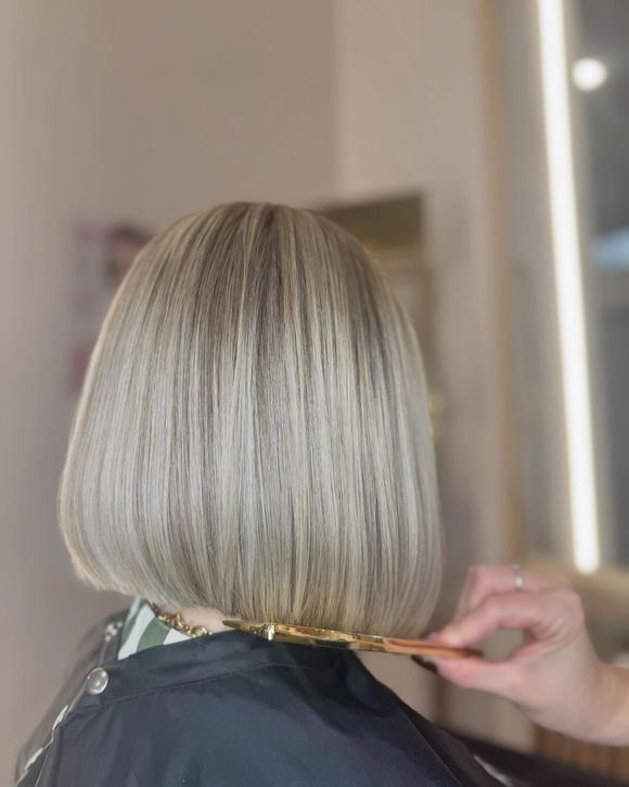 Una donna si sta facendo tagliare i capelli dal parrucchiere in un salone.