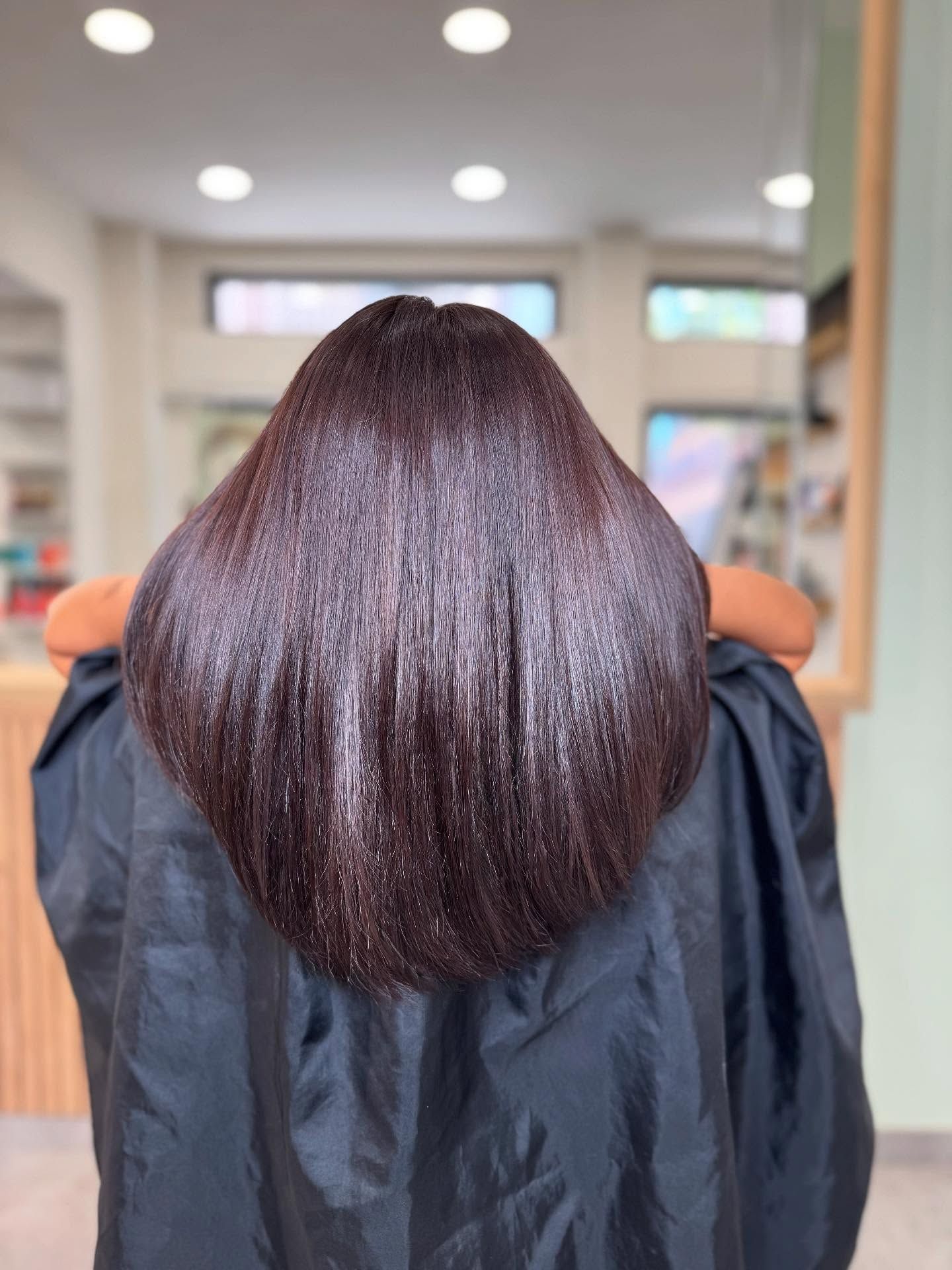 Una donna è seduta su una sedia con i capelli raccolti in un mantello nero.