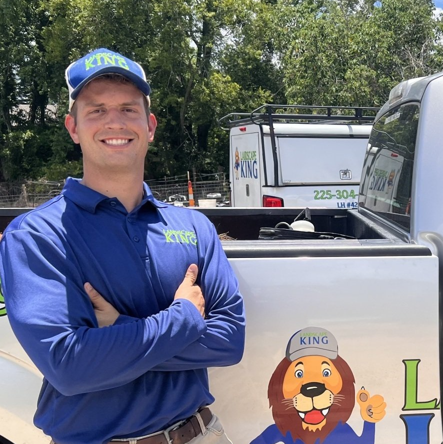 A man in a blue shirt is standing in front of a king truck