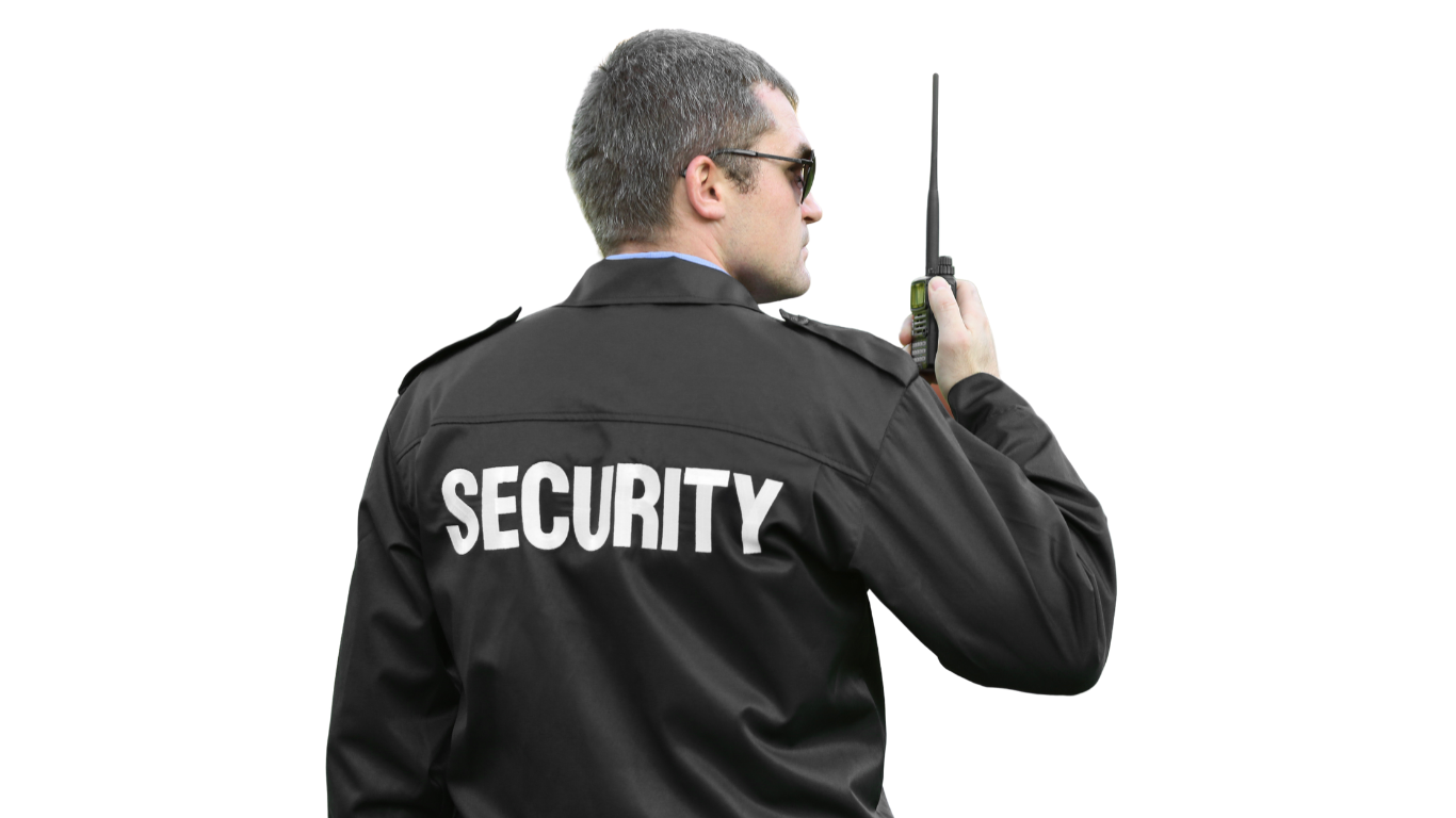 A security guard is talking on a walkie talkie.