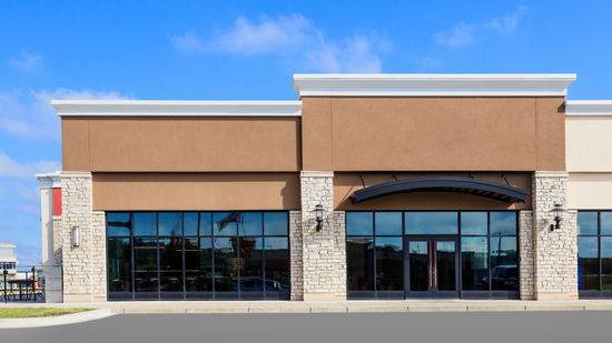 A large building with a lot of windows and a blue sky in the background.