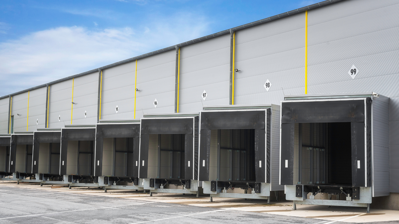 A row of loading docks at a warehouse with a blue sky in the background.