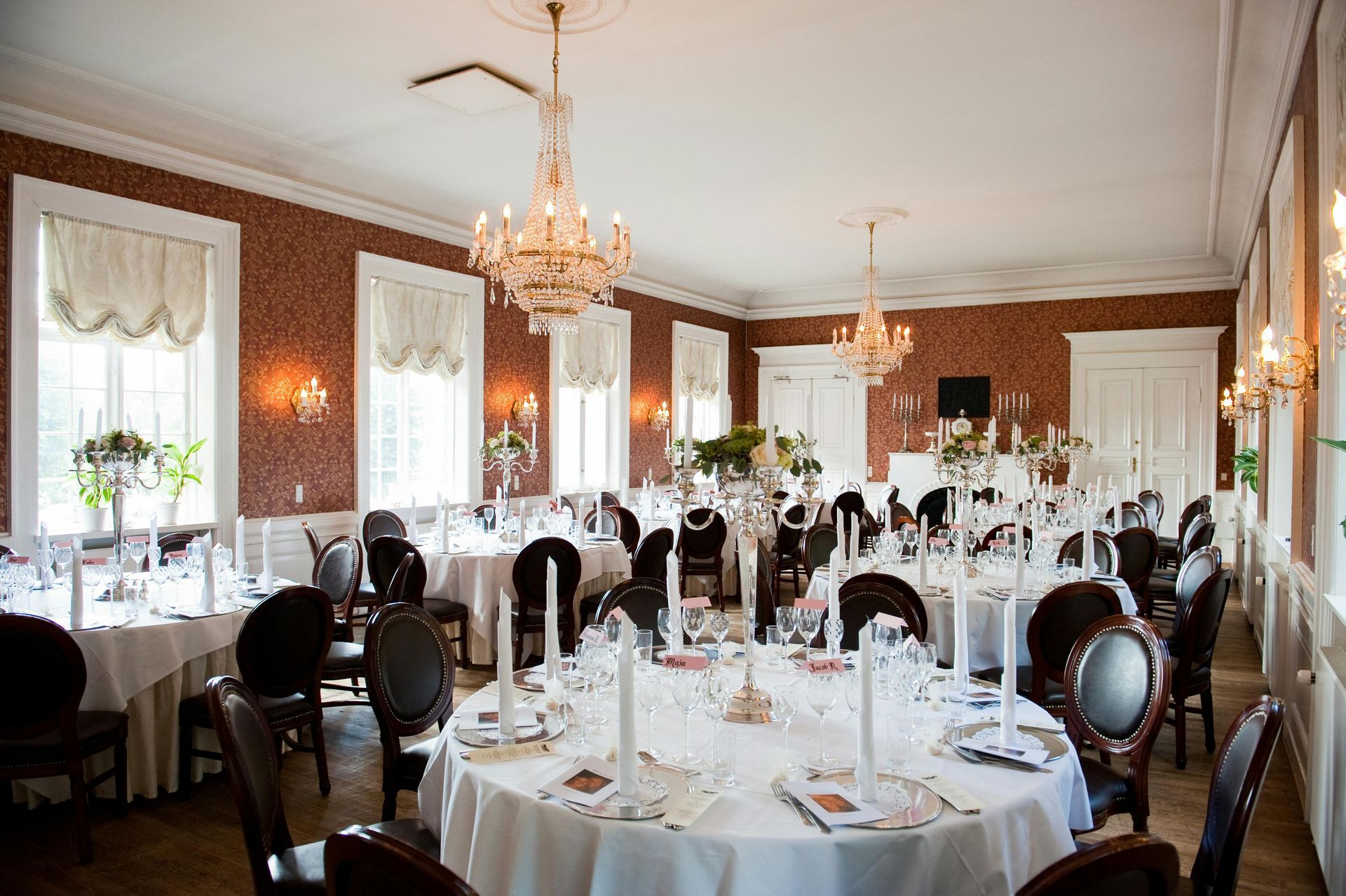 A large dining room with tables and chairs set up for a wedding reception.