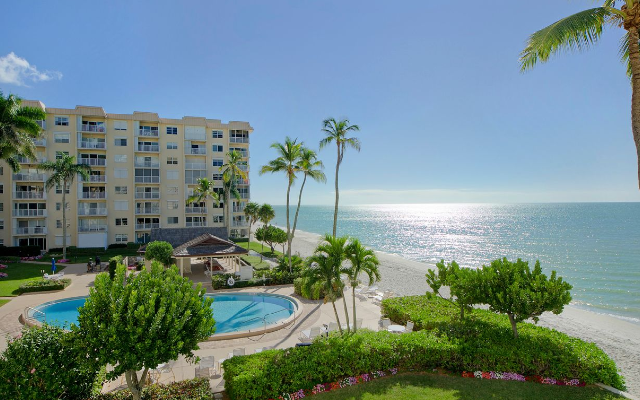 A vase of flowers is sitting on a table next to a window.