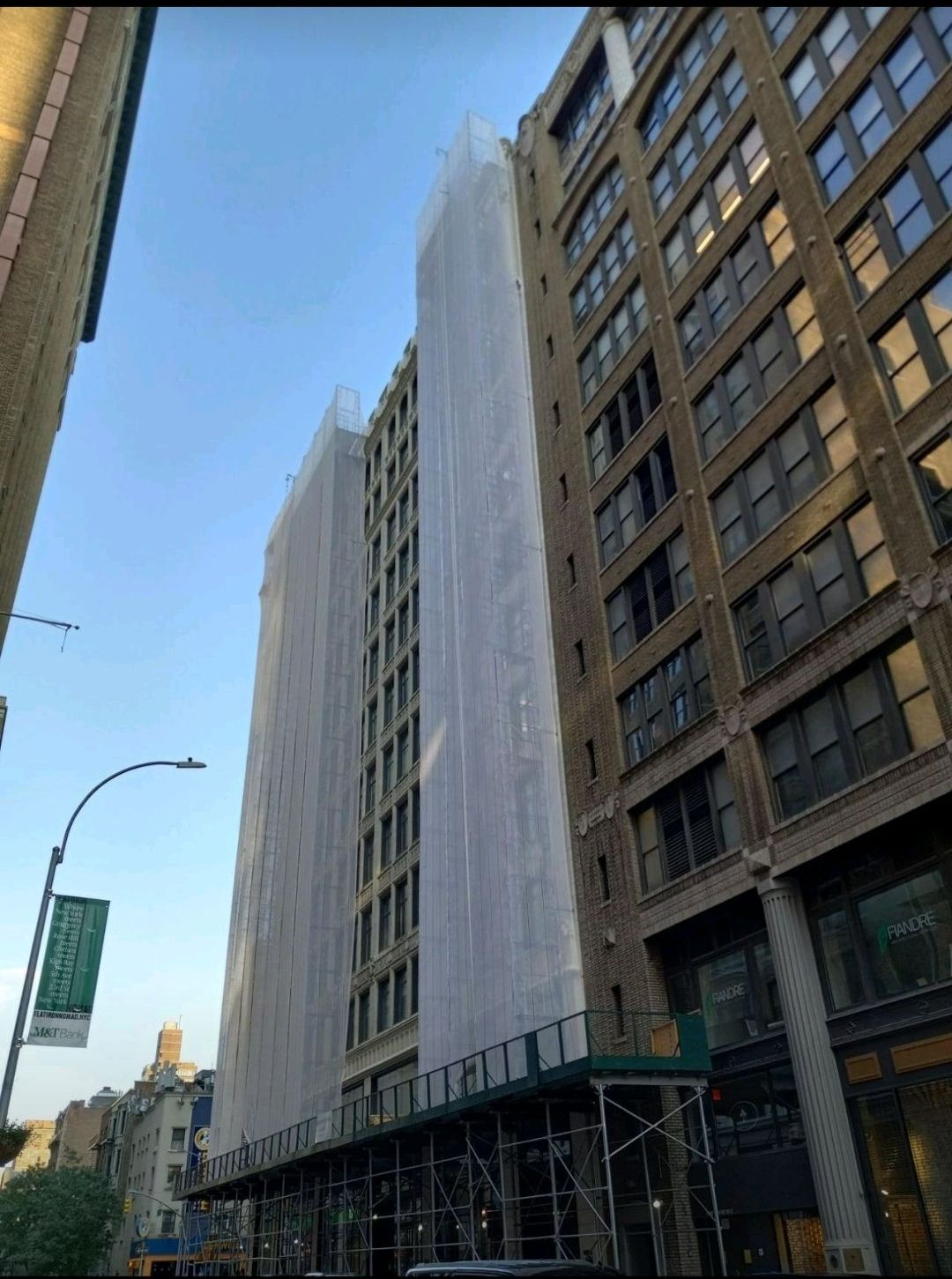 A tall building is being covered in scaffolding.