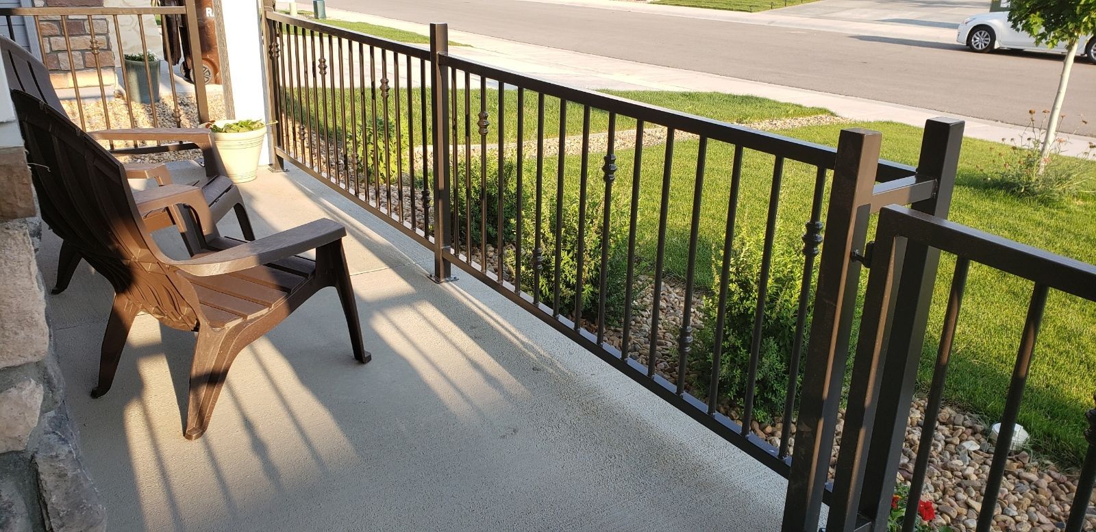 A man wearing a welding mask is working on a fence.