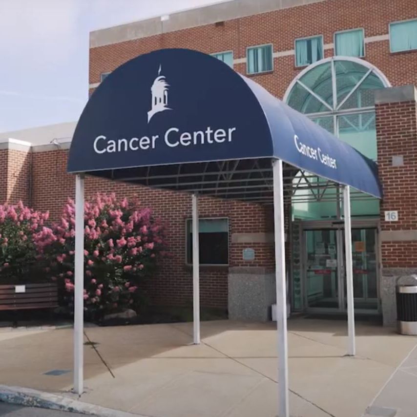 Exterior of Cancer Center building with awning and entrance.