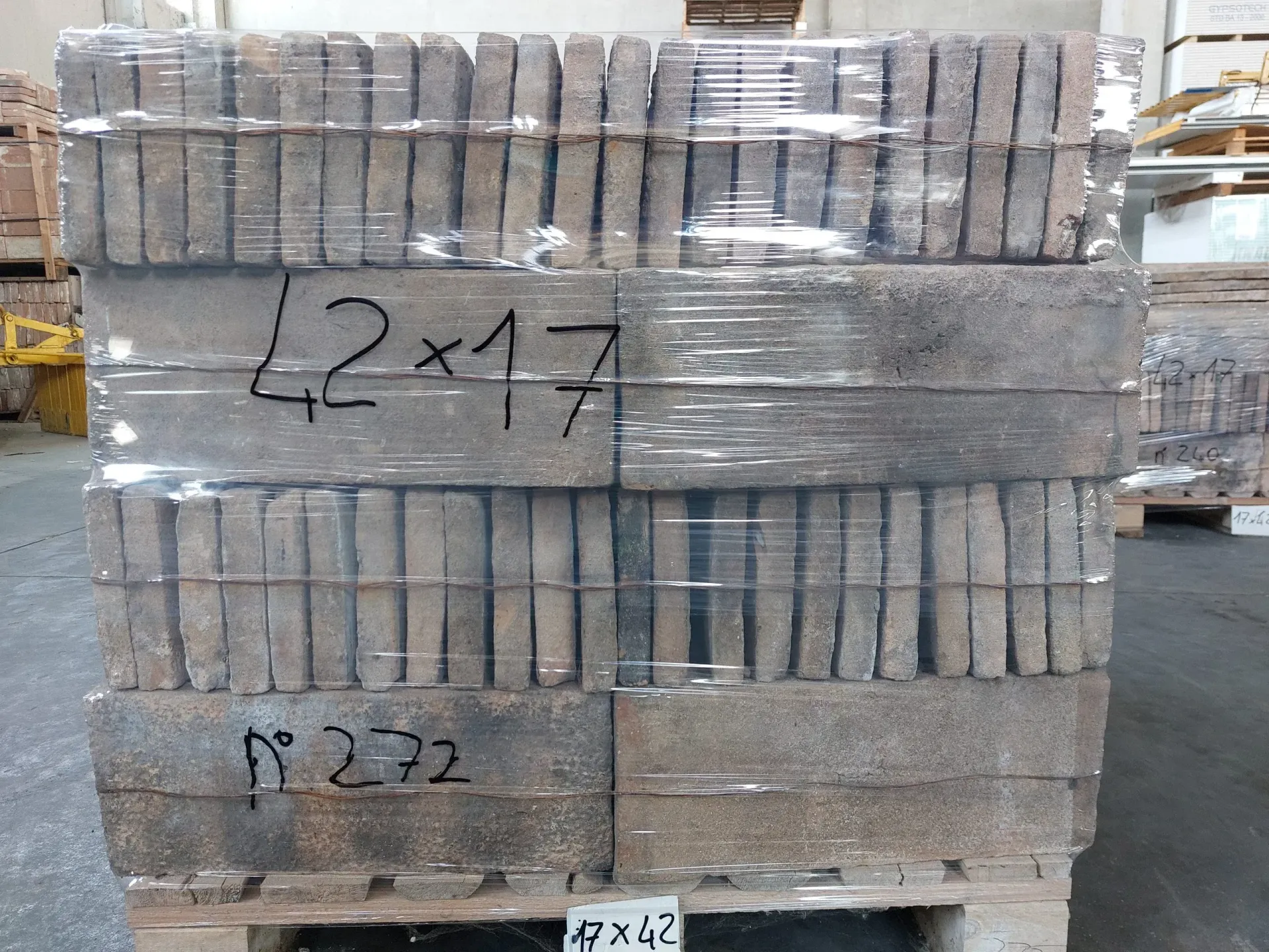 Pallet di mattoni rettangolari avvolti in plastica, con etichette 42x17 e R272.