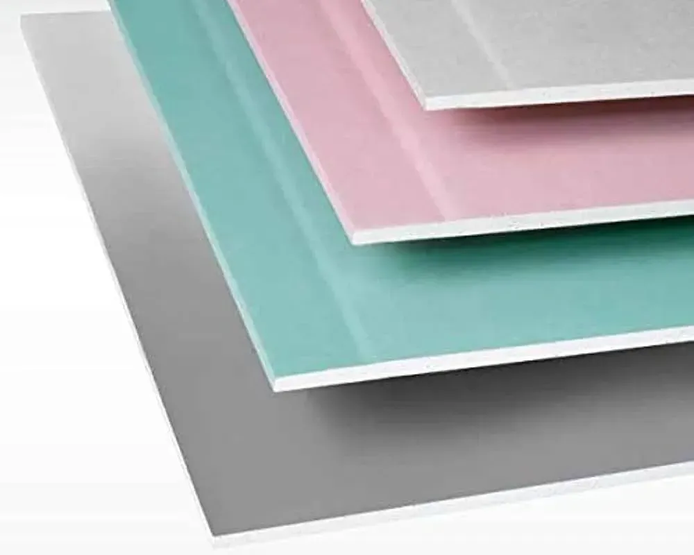Vari pannelli di gesso colorati impilati, tra cui grigio, verde, rosa e bianco.