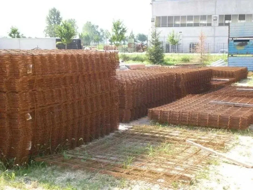 Pile di reti di rinforzo in acciaio arrugginito all'aperto, pronte per la costruzione.