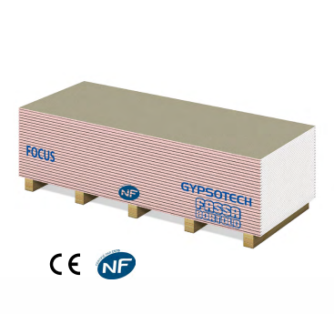 Pila di pannelli in cartongesso Gypsotech Focus, carta rosa, testo blu, su pallet di legno.