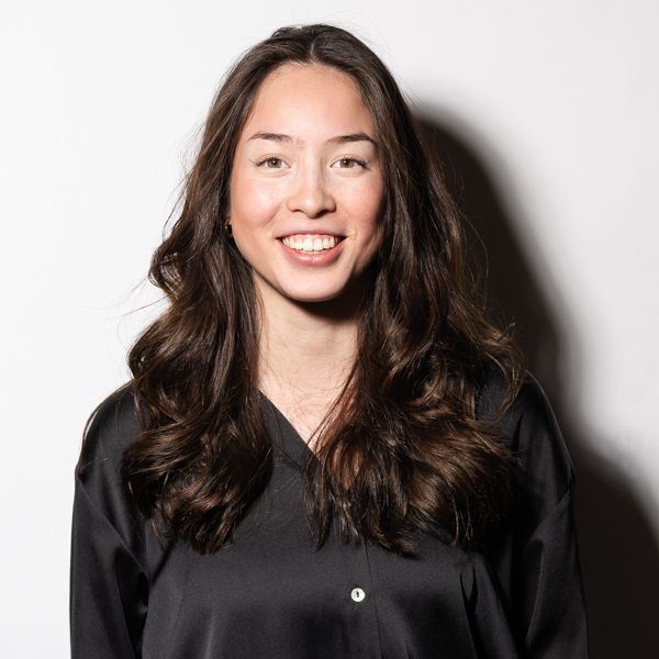 Een vrouw in een zwart shirt lacht naar de camera