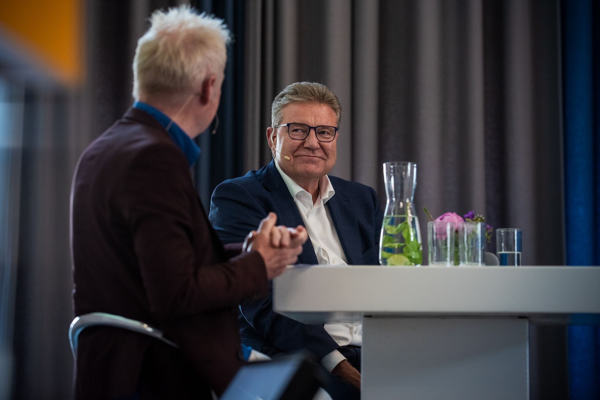 Twee mannen zitten aan een tafel met elkaar te praten.