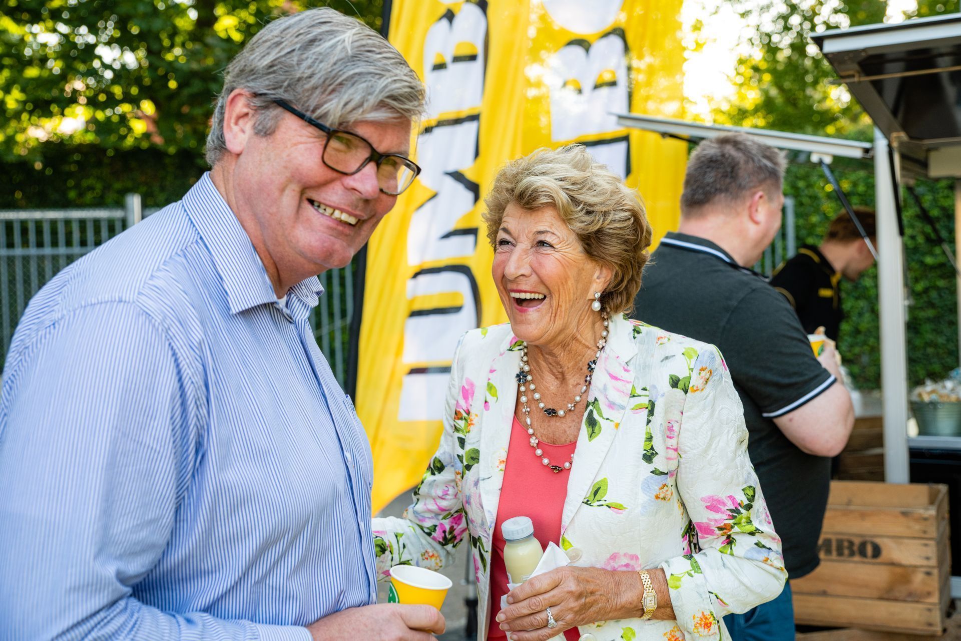 Een man en een vrouw staan naast elkaar en lachen.