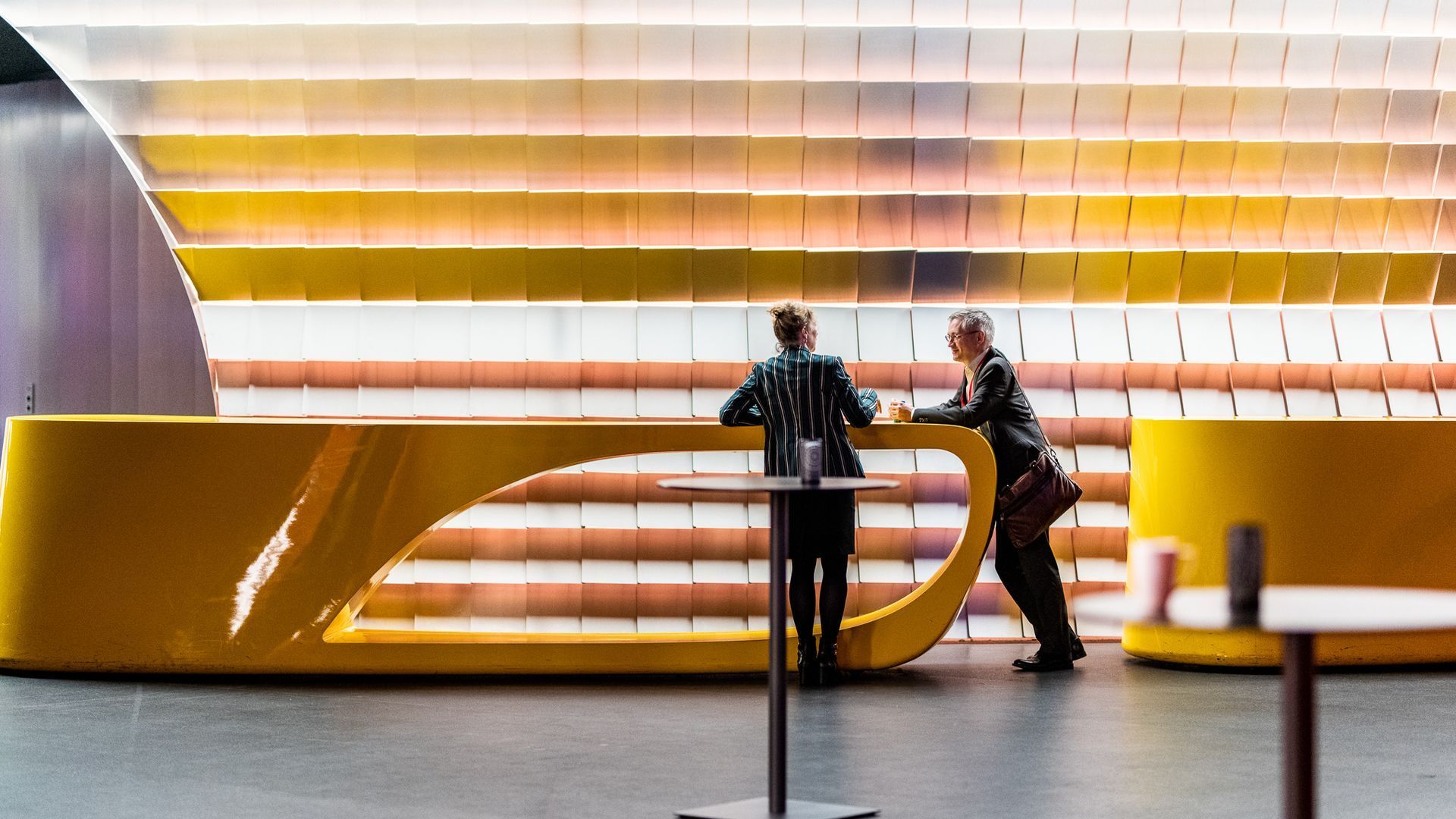 Twee mensen staan aan een balie in een lobby.