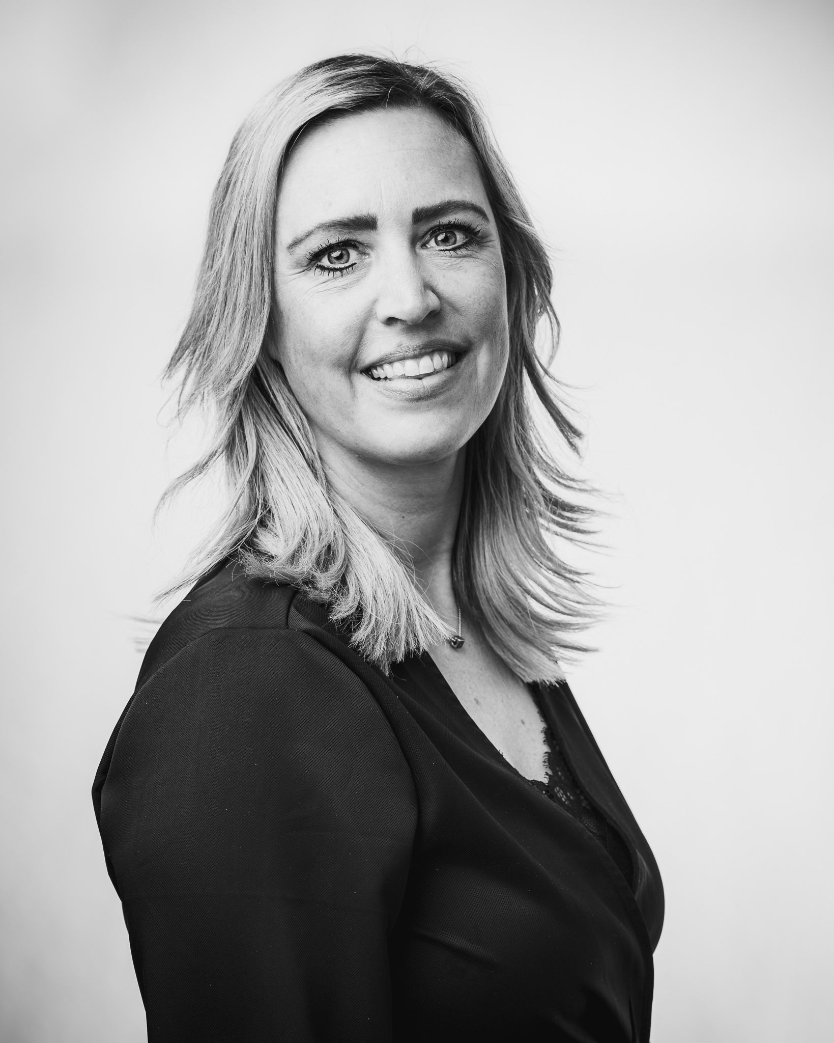 Een vrouw lacht op een zwart-witfoto.