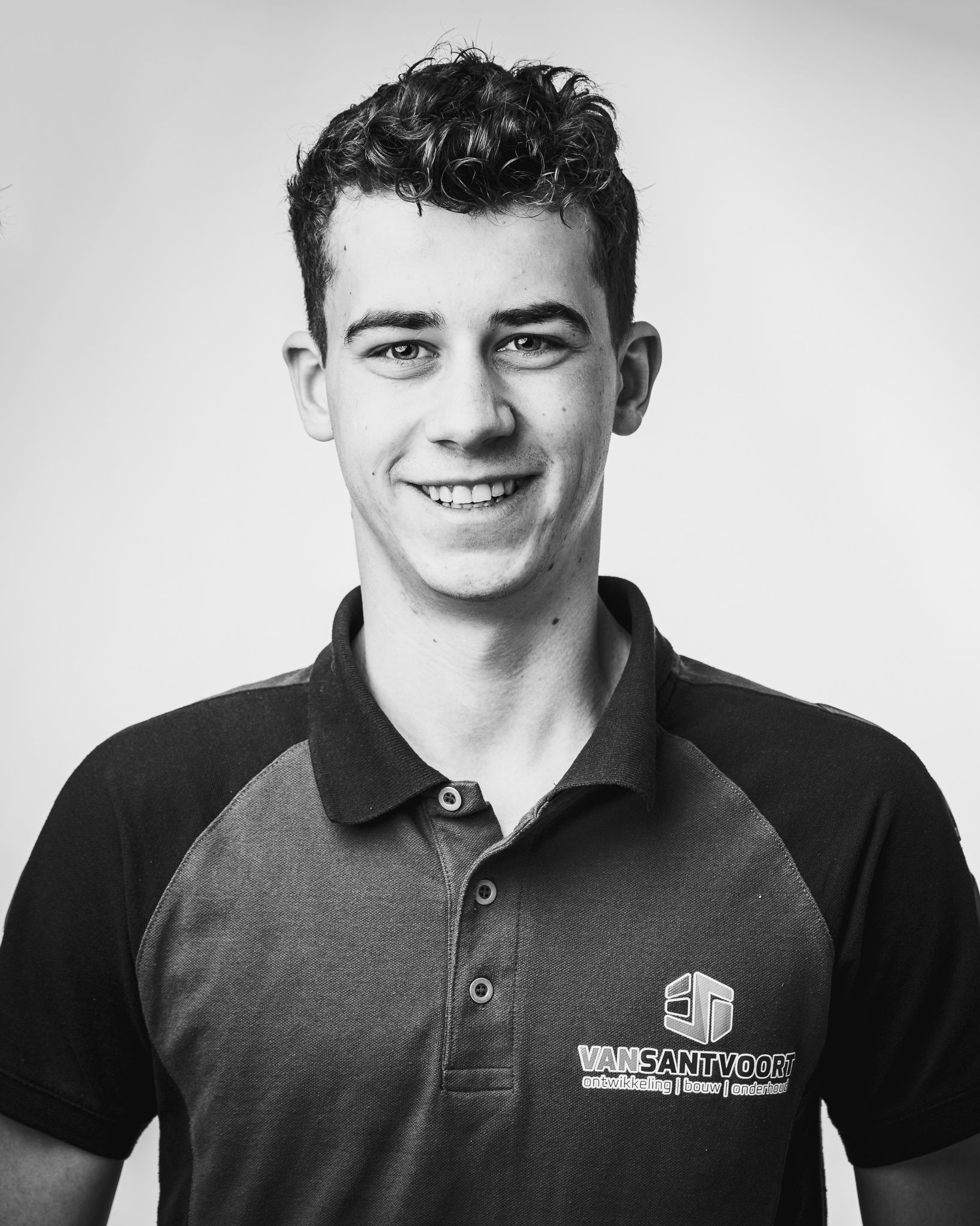 Een zwart-witfoto van een jongeman in een poloshirt