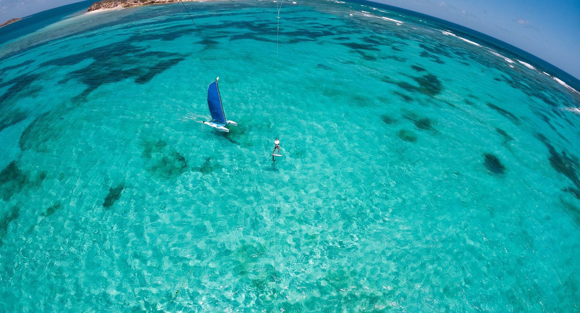 A person is flying a kite in the ocean.