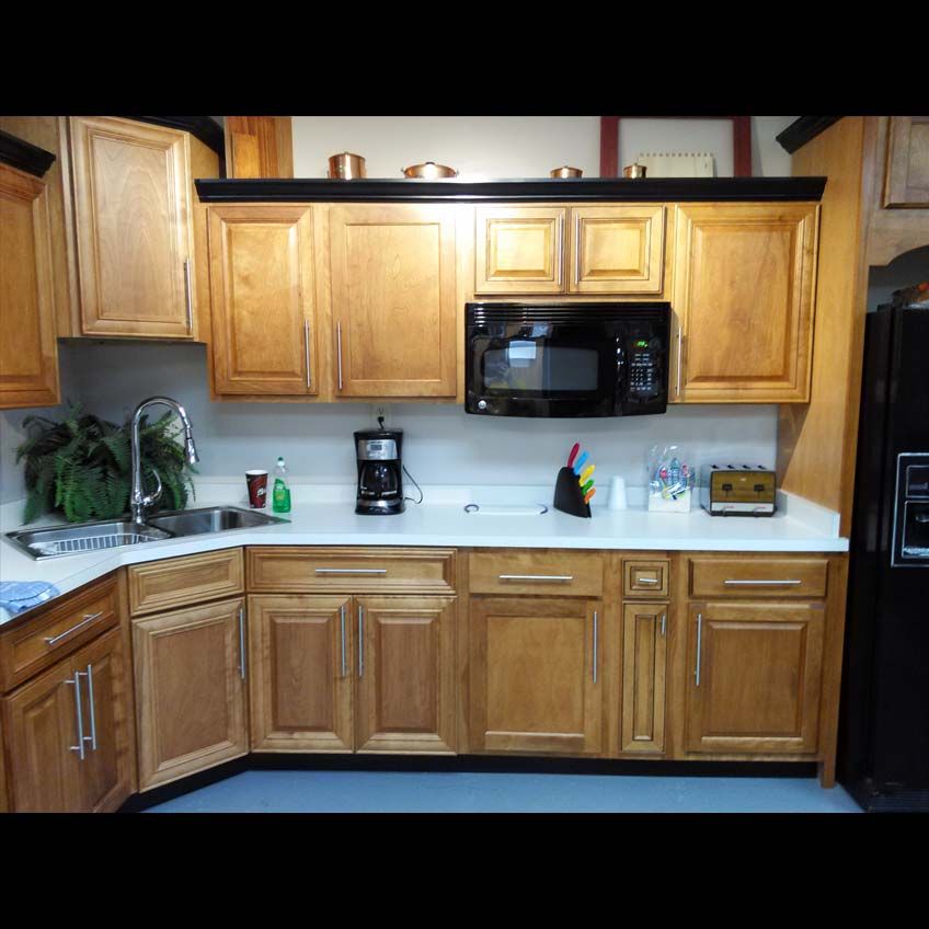 A kitchen with wooden cabinets and a black refrigerator