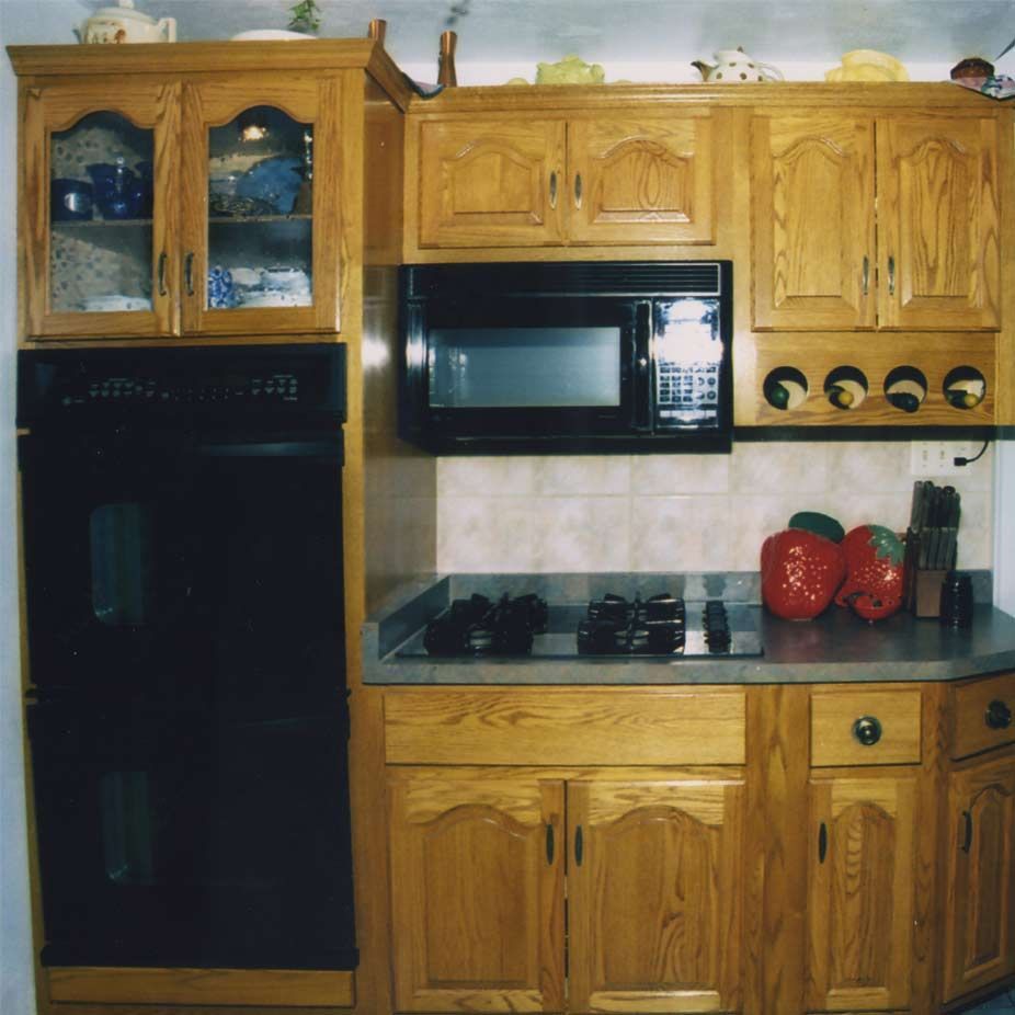 A kitchen with wooden cabinets and a microwave oven