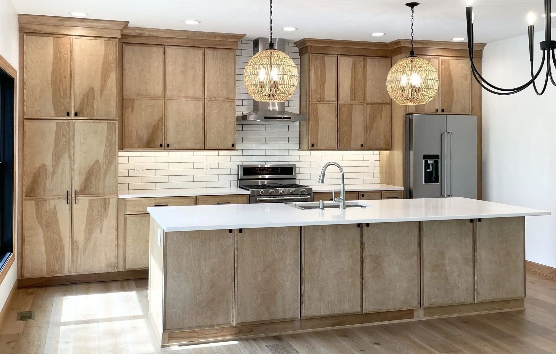 A kitchen with wooden cabinets and a large island