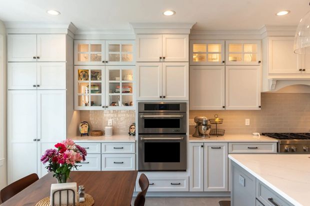 A kitchen with white cabinets and stainless steel appliances.