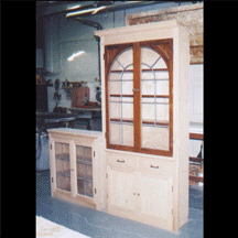 A wooden cabinet with stained glass doors and drawers