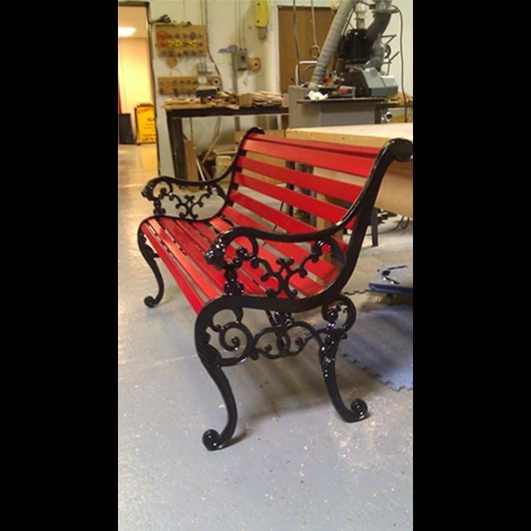 A red bench with black legs is in a room