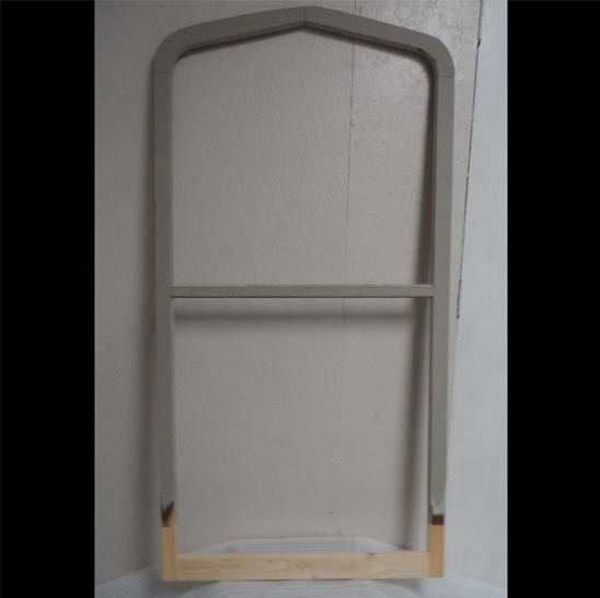 A wooden frame is sitting on a white surface.