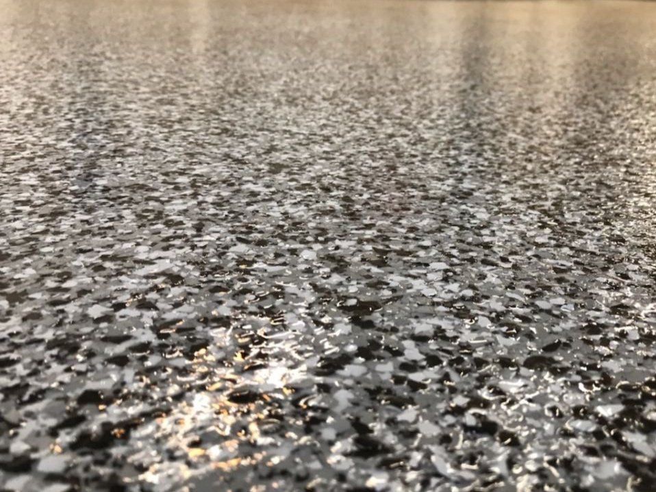 A close up of a garage floor with a lot of small rocks on it.