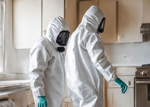 a man in a protective suit and gas mask is standing on a balcony removing asbestos