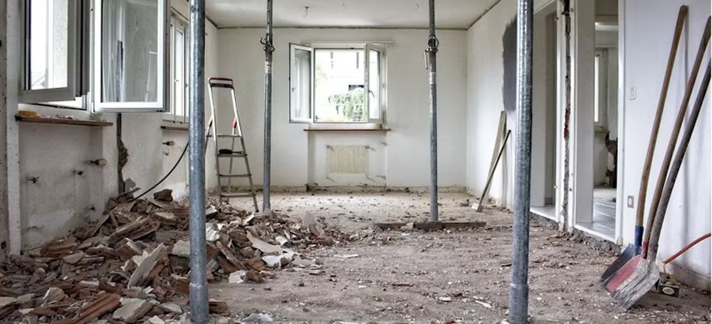 A room that is being remodeled with a lot of trash on the floor.