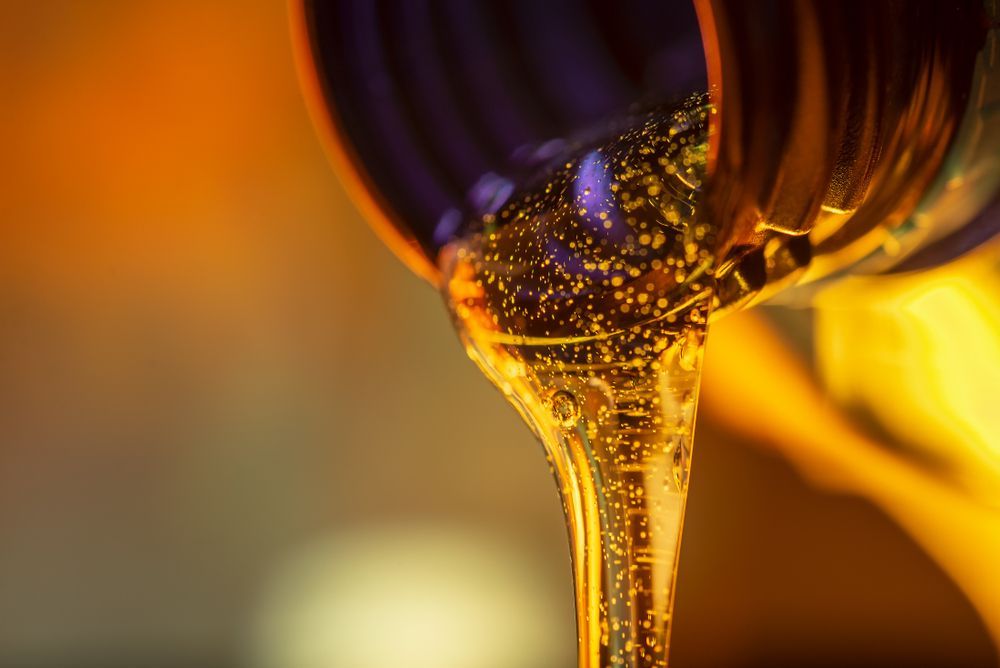 A Close Up of a Bottle of Oil Being Poured Into a Glass — Proton Engineering Pty Ltd In Tamworth, NSW