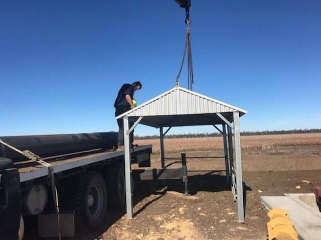 A Man is Standing on Top of a Metal Structure Being Lifted by a Crane — Proton Engineering Pty Ltd In Wee Waa, NSW