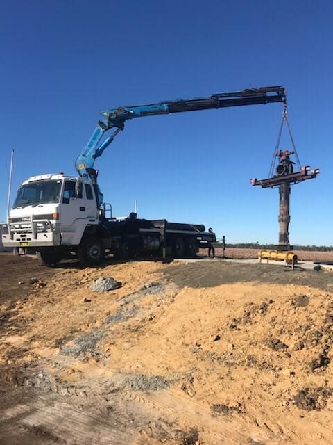 A Truck With a Crane Attached to It is Carrying a Pole — Proton Engineering Pty Ltd In Wee Waa, NSW