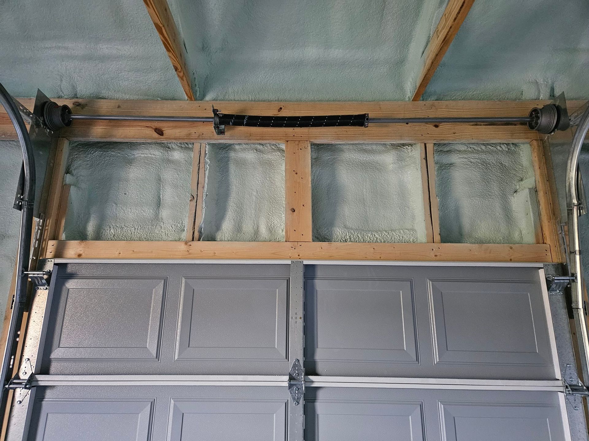 Garage door frame with insulation, and door panels below.