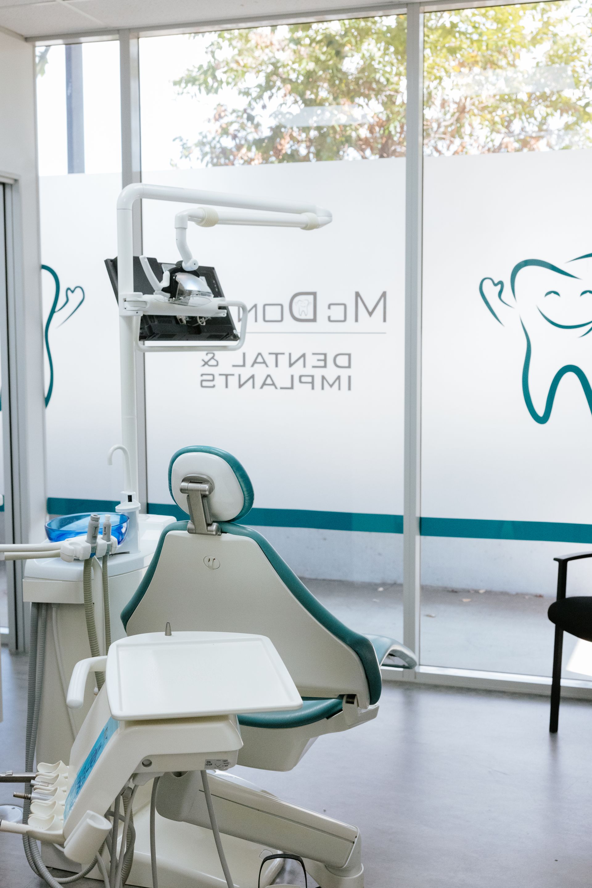 Dental chair in a bright office; frosted window with logo, dental equipment visible. — McDonald Dental in Gympie, QLD