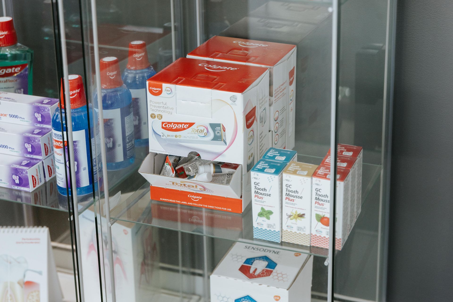Glass display cabinet with oral hygiene products, including mouthwash and toothpaste. — McDonald Dental in Gympie, QLD