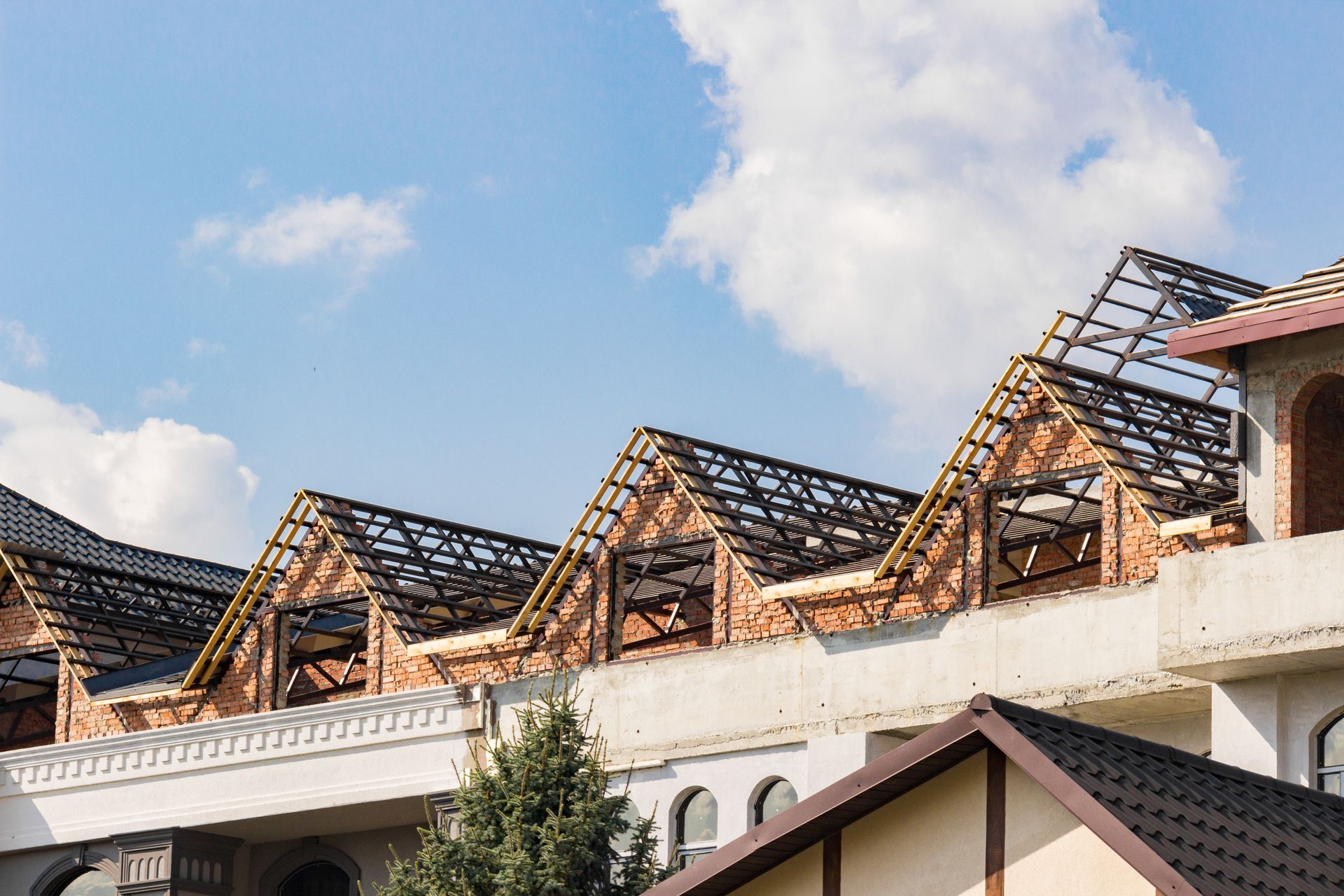 Partially built roof with exposed trusses on a large building